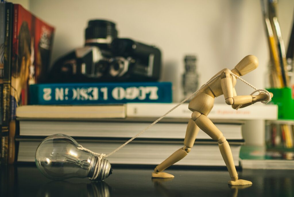 a wooden toy pulling a light bulb on a table